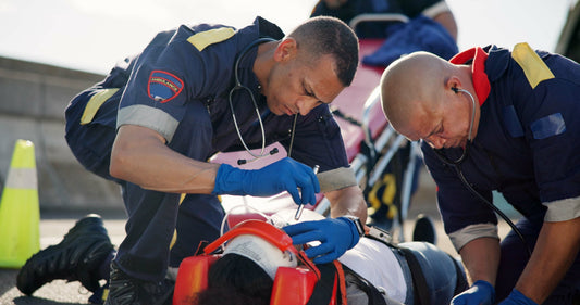 Fotografía de dos paramédicos atendiendo a una persona después de un incidente usando equipos de emergencia.