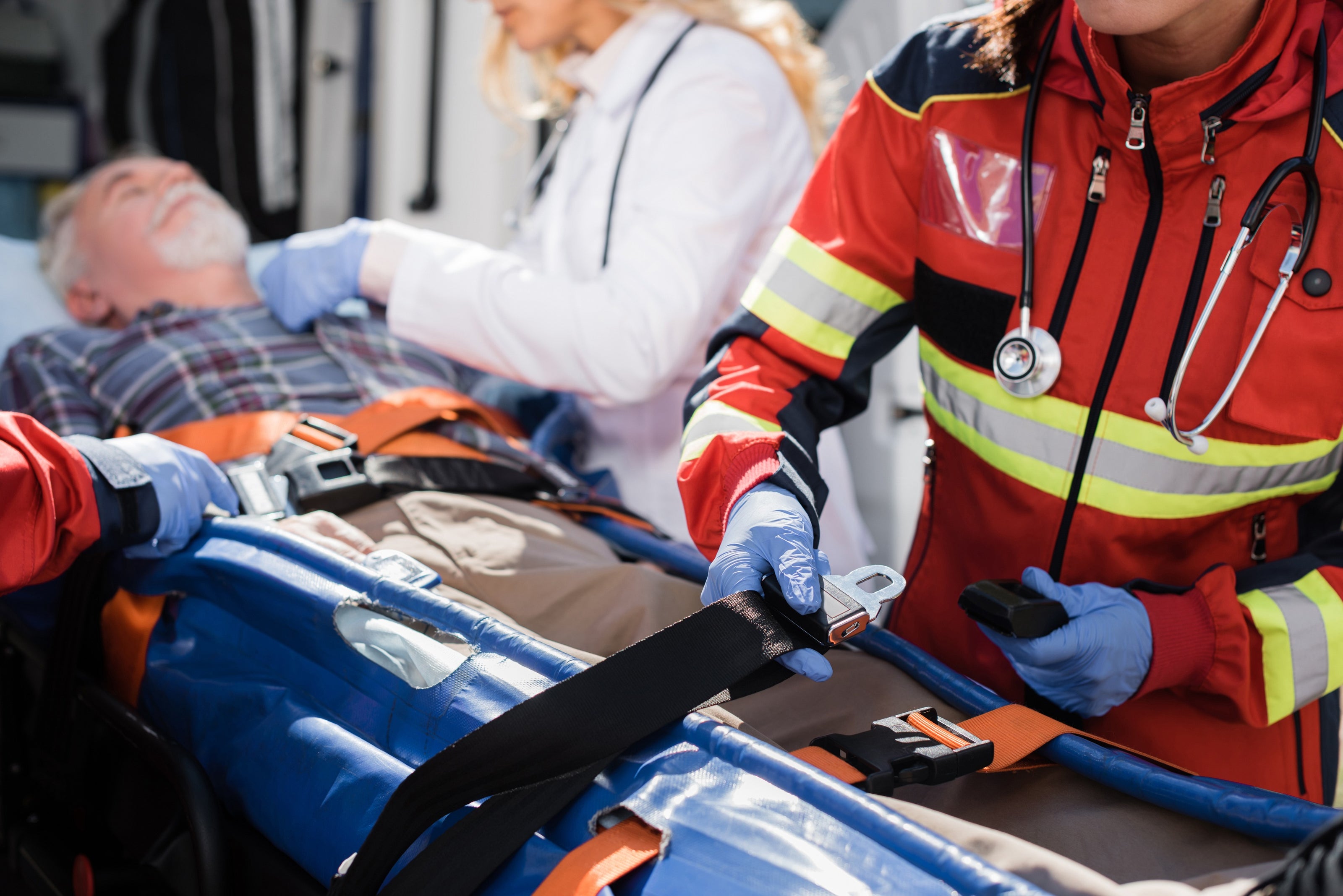 Fotografía de paramédicos asegurando a una persona para transportarla al hospital usando kits de equipo de rescate.