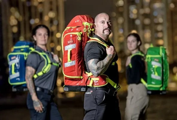 Brigada de primeros auxilios: fotografía de tres personas usando mochilas profesionales de diferentes colores.