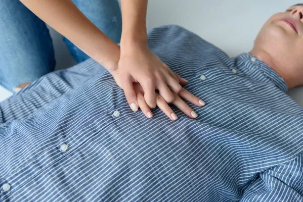 Fotografía de un hombre en el suelo recibiendo RCP en adultos por una persona que está correctamente capacitada.