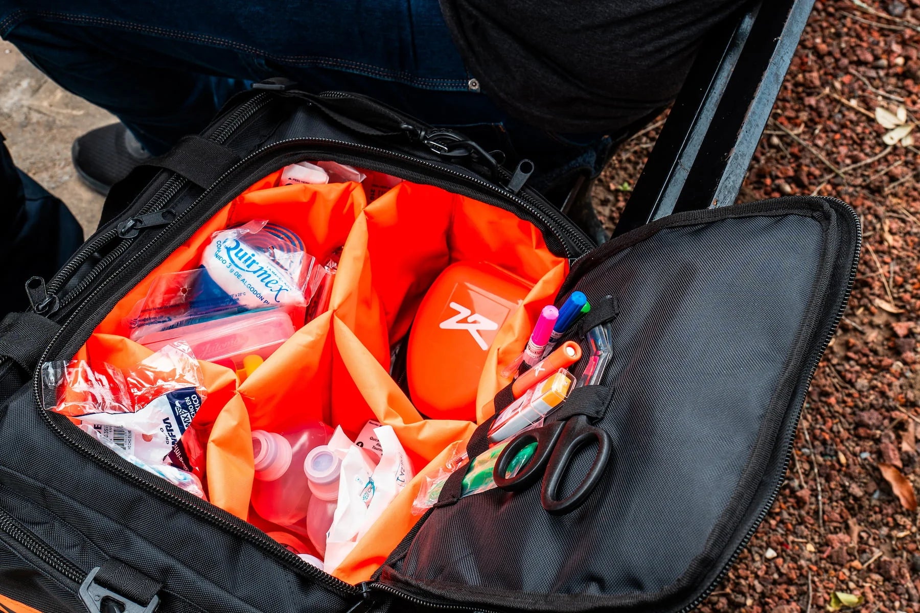 Fotografía desde arriba de uno de los equipos de emergencia de Zona de Rescate en una mochila color negro con naranja.