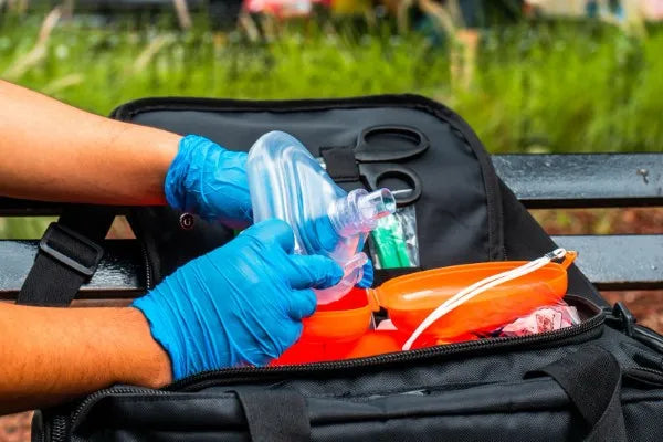Equipo médico de emergencia: guía completa. Fotografía de hombre utilizando guantes azules usando una mascarilla de oxígeno.